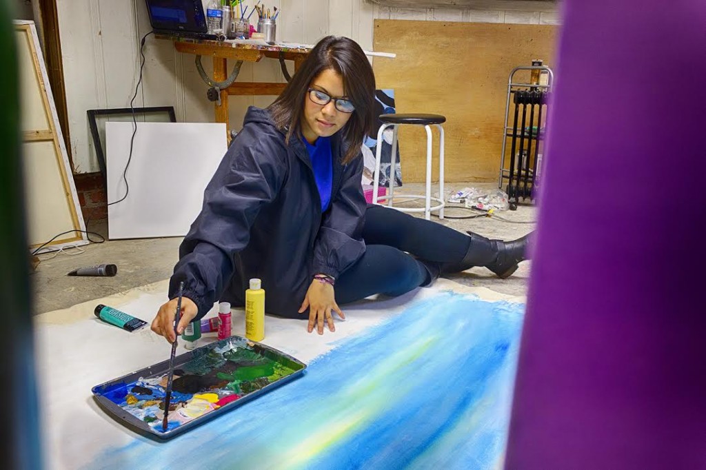 Gaby Guillen works on pieces for her art showcase. 